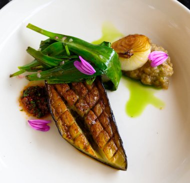 Enfes vejetaryen ızgara patlıcan. Modern Fransız haute mutfağından. Restoranın bahçesinden ve çiftliğinden taze organik malzemelerle hazırlanmış.