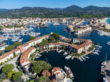 Saint-Tropez Körfezi 'nin mavi suları, tekneler, Port Grimaud ve Cogolin' deki evler, Akdeniz 'deki yatlı köyler, Provence, Fransa' da yaz tatili.