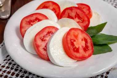 Itaian vejetaryen yemeği, beyaz İtalyan mozzarella peyniri, kırmızı domates ve zeytinyağlı yeşil fesleğen ile yapılmış taze caprese salatası..