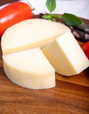 Italian cheese, Provolone dolce cow cheese from Cremona served with olive bread and tomatoes close up. clipart