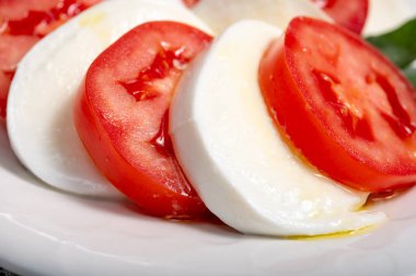 Itaian vejetaryen yemeği, beyaz İtalyan mozzarella peyniri, kırmızı domates ve zeytinyağlı yeşil fesleğen ile yapılmış taze caprese salatası..