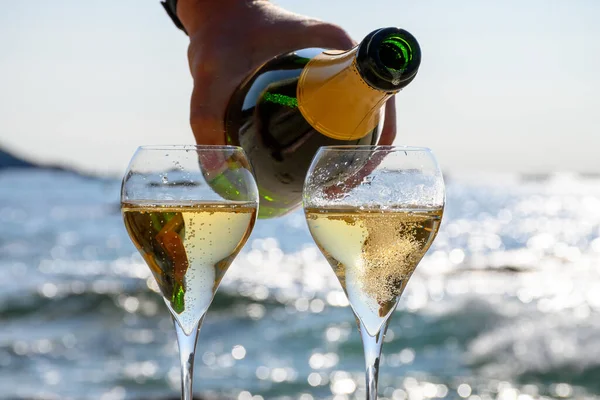 Summer time in Provence, two glasses of cold champagne cremant sparkling wine on sandy beach near Saint-Tropez in sunny day, Var department, vacation in France