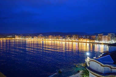 Gijon, Asturias, İspanya 'da gezinti güvertesi, evler ve San Lorenzo plajı gece görüşü