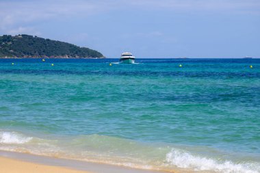 Kristal berrak mavi su ve efsanevi Pampelonne sahilinde Saint-Tropez yakınlarında tekneler, Fransa 'da Fransız Rivierası' nın beyaz kumlu sahillerinde yaz tatili