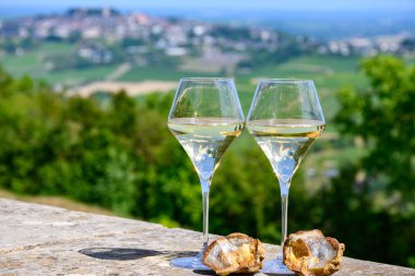 Sancerre Chavignol üzüm bağlarından alınmış beyaz şarap kadehleri ve Sancerre köyü yakınlarındaki çakıl taşı toprağı örneği, Cher, Loire vadisi, Fransa.