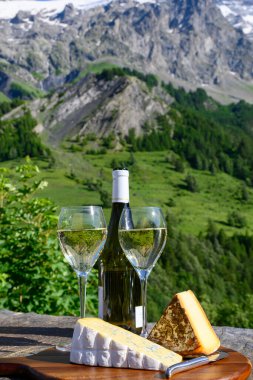 Peynir ve şarap, Savoy bölgesinden beyaz Roussette de Savoie ve Vin de Savoie şarabı ve üstünde karlı Hautes Alpes Dağları manzaralı.