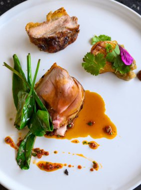 Modern Fransız haute mutfağından nefis, emzirilmiş domuz yemeği. Restoranın bahçesinden ve çiftliğinden taze organik malzemelerle hazırlanmış ve çok güzel servis edilmiş.