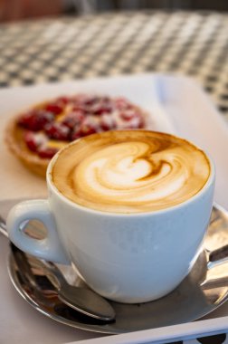 İtalyan barında, beyaz fincanda, sabah kahvesi ve kekte taze kahve kapuçinosu.