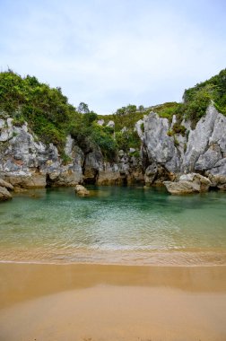 Küçük Playa de Gulpiyuri 'nin manzarası, dünyanın en kısa sahili olan Cantabrian Denizi' ne yaklaşık 100 metre mesafedeki, İspanya 'nın Asturias kentindeki Llanes yakınlarındaki iç sahil subatanı.