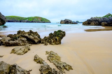 Celorio 'daki Playa de Borizo' daki kayalara bakın. Kuzey İspanya, Asturias 'ın yeşil kıyıları. Beyaz kumlu plajlar, uçurumlar, gizli mağaralar, yeşil tarlalar, ormanlar ve dağlar..