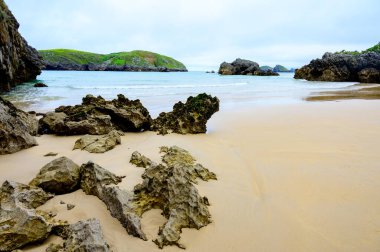 Celorio 'daki Playa de Borizo' daki kayalara bakın. Kuzey İspanya, Asturias 'ın yeşil kıyıları. Beyaz kumlu plajlar, uçurumlar, gizli mağaralar, yeşil tarlalar, ormanlar ve dağlar..