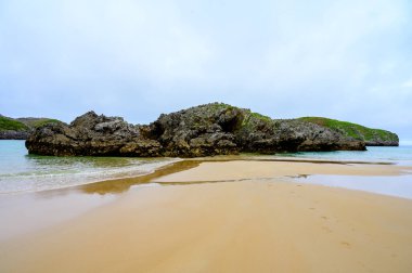 Celorio 'daki Playa de Borizo' daki kayalara bakın. Kuzey İspanya, Asturias 'ın yeşil kıyıları. Beyaz kumlu plajlar, uçurumlar, gizli mağaralar, yeşil tarlalar, ormanlar ve dağlar..
