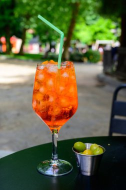 Garson Aperol Sprits yaz kokteylini Aperol, Prosecco, buz küpleri, tonik su ve portakalla hazırladı, güneşli terasta içmeye hazır.