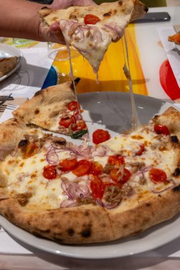 İtalyan pizzacı restoranında taze pişmiş pizza yemek, yakın plan.