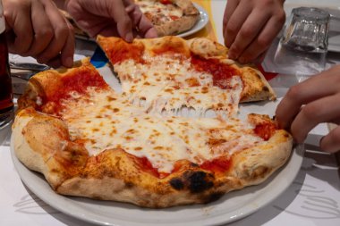 İtalyan pizzacı restoranında taze pişmiş pizza yemek, yakın plan.