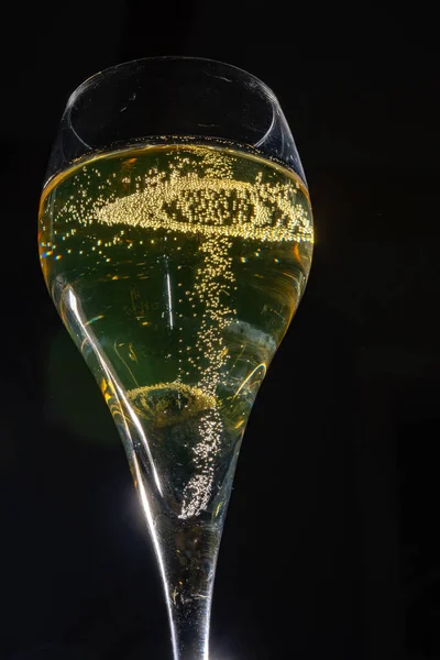 濃い背景の泡が付いているフランスのスパークリング シャンパン ワインのガラス 金の泡は閉まります — ストック写真