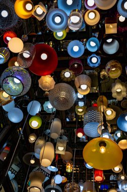 Karanlık odada lamba ve duvar aynası olan bir sürü farklı tavan lambası.