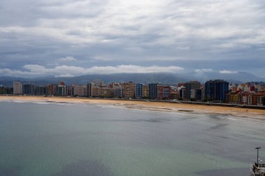 Gijon, Asturias, İspanya 'daki gezinti güvertesi, evler ve San Lorenzo plajına bakın.