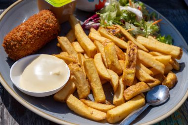 Hollanda fast food 'u, kıymalı kızartma ve patates cipsi ile doldurulmuş mayonez, yeşil salata, yakın çekim.