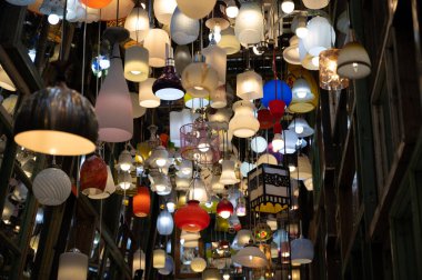 Karanlık odada lamba ve duvar aynası olan bir sürü farklı tavan lambası.