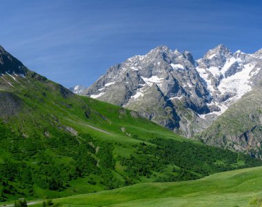 Dağlar ve yeşil alp çayırları Col du Lautaret, Massif des Ecrins, Hautes Alpes, Fransa yakınlarındaki yazlık alanları