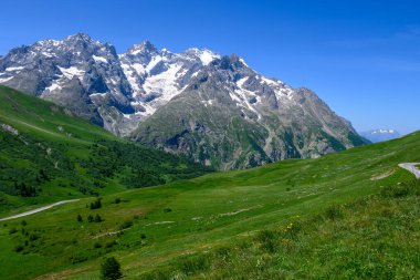 Dağlar ve yeşil alp çayırları Col du Lautaret, Massif des Ecrins, Hautes Alpes, Fransa yakınlarındaki yazlık alanları