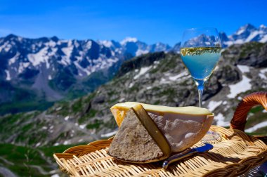 Peynir koleksiyonu, Fransız Alpleri 'ndeki Savoy bölgesinden Reblochon ve Tomme de Savoie peyniri, açık havada hafif inek sütü, Fransız Alpler dağlarının karlı tepelerinde manzara