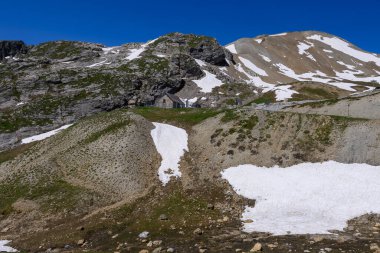 Col de Lautaret 'ten Col du Calibier' e, Dağlar 'a ve yazın Massif des Ecrins, Hautes Alpes, Fransa' nın yeşil dağlık manzarasına dar dağlar.