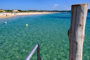 Saint-Tropez yakınlarındaki efsanevi Pampelonne sahilinin berrak mavi suları Fransız Riviera, Fransa, Cote d 'Azur' un beyaz kumlu sahillerinde yaz tatili.