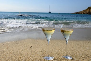 Provence 'de yaz zamanı, iki bardak soğuk şampanya. Güneşli bir günde Saint-Tropez yakınlarındaki kumlu plajda köpüklü şarap. Var Bölümü, Fransa' da tatil.