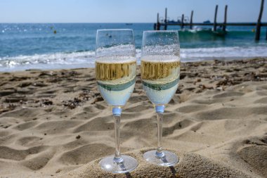 Provence 'de yaz mevsimi, iki bardak soğuk şampanya krep şarabı güneşli bir günde Saint-Tropez yakınlarındaki ünlü Pampelonne kumlu plajında, Var Bölümü, Fransa' da vanation