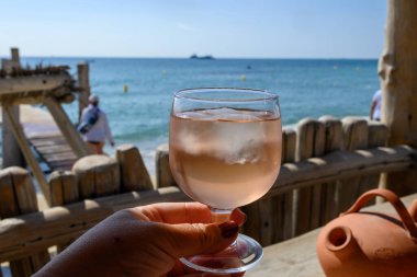 Provence 'de yaz partisi zamanı, güneşli bir günde Saint-Tropez yakınlarındaki Pampelonne kumsalında buzlu bir bardak gül şarabı, Var Bölümü, Fransa