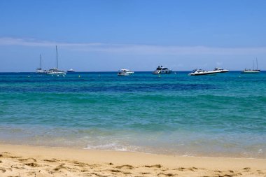 Kristal berrak mavi su ve efsanevi Pampelonne sahilinde Saint-Tropez yakınlarında tekneler, Fransa 'da Fransız Rivierası' nın beyaz kumlu sahillerinde yaz tatili
