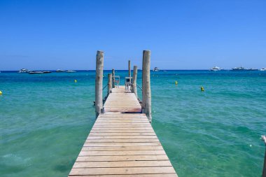 Ramatuelle ve Saint-Tropez yakınlarındaki efsanevi Pampelonne sahilinin ahşap iskelesi ve berrak mavi suyu, Fransa 'nın Riviera kentinde yaz tatili.