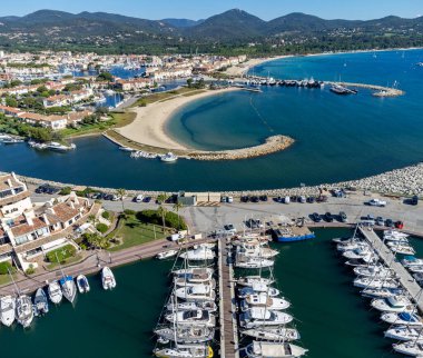 Saint-Tropez Körfezi 'nin mavi suları, tekneler, Port Grimaud ve Cogolin' deki evler, Akdeniz 'deki yatlı köyler, Provence, Fransa' da yaz tatili.