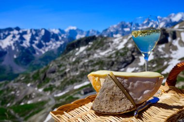 Peynir koleksiyonu, Fransız Alpleri 'ndeki Savoy bölgesinden Reblochon ve Tomme de Savoie peyniri, açık havada hafif inek sütü, Fransız Alpler dağlarının karlı tepelerinde manzara