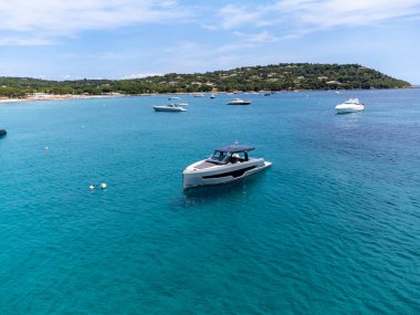 Botlardaki hava manzarası, Saint-Tropez yakınlarındaki efsanevi Pampelonne sahilinin kristal berrak mavi suyu, Fransız Riviera, Var, Fransa 'nın beyaz kumlu plajında yaz tatili