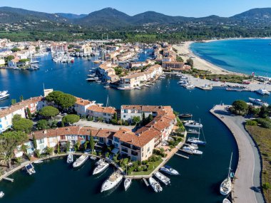 Saint-Tropez Körfezi 'nin mavi suları, tekneler, Port Grimaud ve Cogolin' deki evler, Akdeniz 'deki yatlı köyler, Provence, Fransa' da yaz tatili.