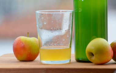 Traditional natural Asturian cider made from fermented apples in wooden barrel should be poured from great height for air bubbles into the drink and view on Gijon, Asturias, Spain clipart