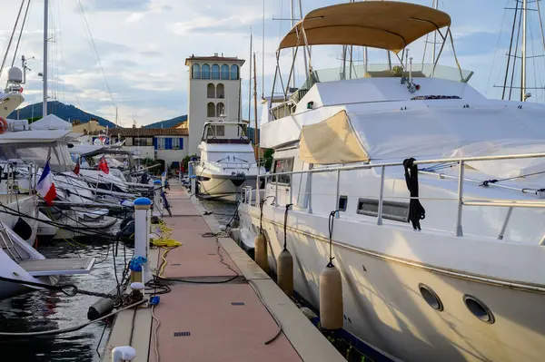 Akdeniz kıyısındaki Port Grimaud 'da büyük beyaz yatlar ve renkli evler, yat limanı, Provence, Fransa' da yaz tatili.