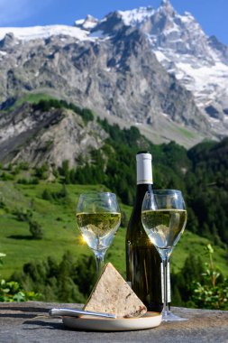 Peynir ve şarap, Savoy bölgesinden beyaz Roussette de Savoie ve Vin de Savoie şarabı ve üstünde karlı Hautes Alpes Dağları manzaralı.