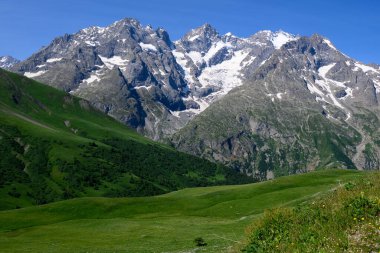 Dağlar ve yeşil alp çayırları Col du Lautaret, Massif des Ecrins, Hautes Alpes, Fransa yakınlarındaki yazlık alanları