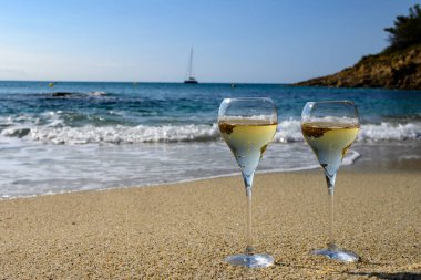 Provence 'de yaz zamanı, iki bardak soğuk şampanya. Güneşli bir günde Saint-Tropez yakınlarındaki kumlu plajda köpüklü şarap. Var Bölümü, Fransa' da tatil.