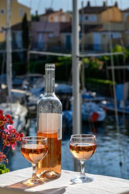 Port Grimaud limanında yat limanında soğuk gül Cote de Provence şarabı, Fransa 'nın Provence şehrinde Fransız Rivierası' nda yaz tatili.