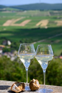 Sancerre Chavignol üzüm bağlarından alınmış beyaz şarap kadehleri ve Sancerre köyü yakınlarındaki çakıl taşı toprağı örneği, Cher, Loire vadisi, Fransa.