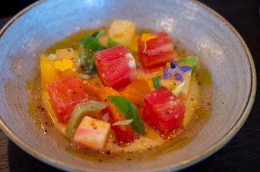 Renkli sağlıklı salata dilimlenmiş çiğ Fransız domatesleri taze keçi sütlü burrata peyniri ve salata sosuyla servis edilir.