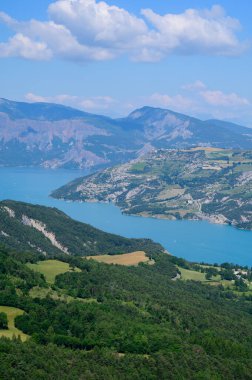 Serre-Poncon 'un mavi gölü üzerindeki hava manzarası, Hautes-Alpes ve Haute-de-Haute Provence departmanları arasındaki rezervuar sınırı, Batı Avrupa' nın en büyük bölümlerinden biri.