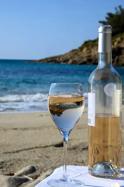 Summer time in Provence, two glasses of cold rose wine on sandy beach near Saint-Tropez in sunny day, Var department, France.