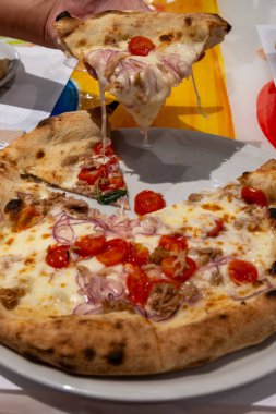 İtalyan pizzacı restoranında taze pişmiş pizza yemek, yakın plan.