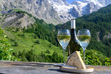 Peynir ve şarap, Savoy bölgesinden beyaz Roussette de Savoie ve Vin de Savoie şarabı ve yazın üstleri karlı Hautes Alpes dağları manzaralı..